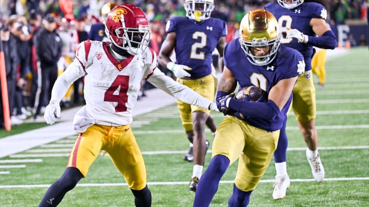 Oct 14, 2023; South Bend, Indiana, USA; Notre Dame Fighting Irish safety Xavier Watts (0) scores a touchdown in front of USC Trojans wide receiver Mario Williams (4) after a fumble recovery in the fourth quarter at Notre Dame Stadium. Notre Dame won 48-20. Mandatory Credit: Matt Cashore-USA TODAY Sports