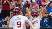 Arkansas Razorbacks third baseman Brent Iredale (10) celebrates as shortstop Wehiwa Aloy (9) scores on a two RBI double by right fielder Logan Maxwell (22) against the UCLA Bruins during the seventh inning at Charles Schwab Field. 
