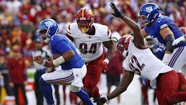 New York Giants quarterback Russell Wilson, left, runs away from pass rush