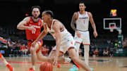 Dec 7, 2024; Coral Gables, Florida, USA; Miami Hurricanes guard Divine Ugochukwu (99) drives to the basket past Clemson Tigers guard Jaeden Zackery (11) during the second half at Watsco Center. Mandatory Credit: Sam Navarro-Imagn Images