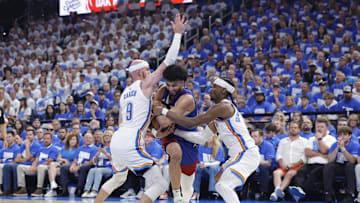 May 13, 2025; Oklahoma City, Oklahoma, USA; Denver Nuggets guard Jamal Murray (27) drives between Oklahoma City Thunder guard Alex Caruso (9) and guard Shai Gilgeous-Alexander (2) during the second quarter of game five of the second round for the 2025 NBA Playoffs at Paycom Center. Mandatory Credit: Alonzo Adams-Imagn Images