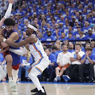May 13, 2025; Oklahoma City, Oklahoma, USA; Denver Nuggets guard Jamal Murray (27) drives between Oklahoma City Thunder guard Alex Caruso (9) and guard Shai Gilgeous-Alexander (2) during the second quarter of game five of the second round for the 2025 NBA Playoffs at Paycom Center. Mandatory Credit: Alonzo Adams-Imagn Images