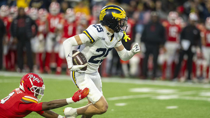 Nov 22, 2025; College Park, Maryland, USA;  Michigan Wolverines defensive back Mason Curtis (25) returns a first half interception as Maryland Terrapins wide receiver Shaleak Knotts (4) dives to tackle at SECU Stadium. Mandatory Credit: Tommy Gilligan-Imagn Images