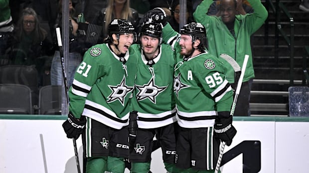 Hockey players in green uniforms celebrate a goal score