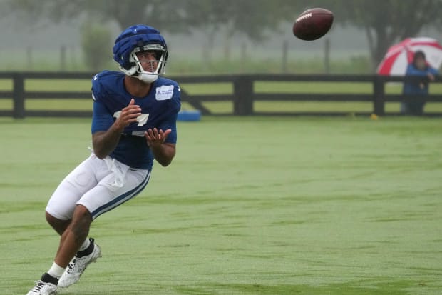 Football player Michael Pittman Jr. catches a ball during practice in a blue jersey.