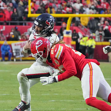 Jan 18, 2025; Kansas City, Missouri, USA; Houston Texans quarterback C.J. Stroud (7) is tackled by Kansas City Chiefs safety Justin Reid (20) during the second half of a 2025 AFC divisional round game at GEHA Field at Arrowhead Stadium. Mandatory Credit: Denny Medley-Imagn Images