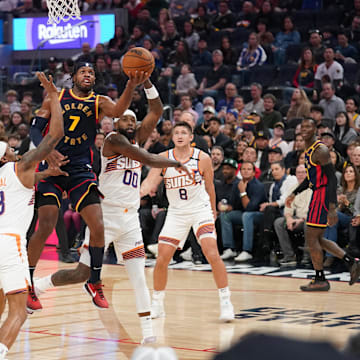 Jan 31, 2025; San Francisco, California, USA; Golden State Warriors guard Buddy Hield (7) makes a layup over Phoenix Suns guard Bradley Beal (3) in the second quarter at the Chase Center. Mandatory Credit: Cary Edmondson-Imagn Images