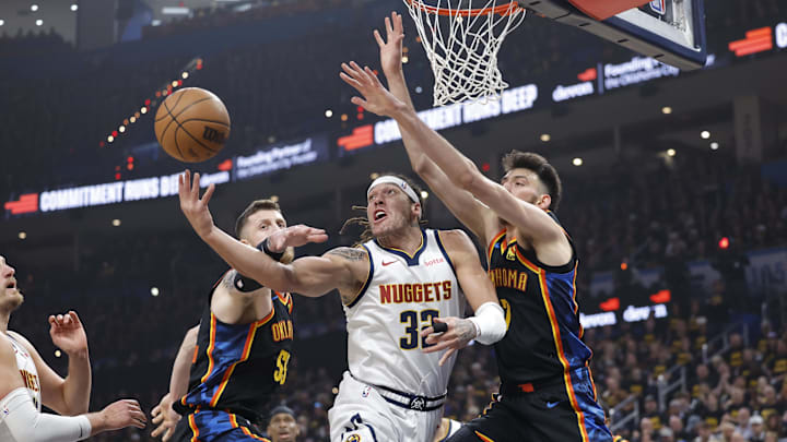 May 7, 2025; Oklahoma City, Oklahoma, USA; Denver Nuggets forward Aaron Gordon (32) shoots from under the basket between Oklahoma City Thunder center Isaiah Hartenstein (55) and forward Chet Holmgren (7) in the first quarter during game two of the second round for the 2025 NBA Playoffs at Paycom Center. Mandatory Credit: Alonzo Adams-Imagn Images