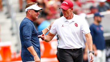 Sep 20, 2025; Norman, Oklahoma, USA;  Auburn Tigers head coach Hugh Freeze (left) speaks with Oklahoma Sooners head coach Brent Venables (right) before the game at Gaylord Family-Oklahoma Memorial Stadium. Mandatory Credit: Kevin Jairaj-Imagn Images