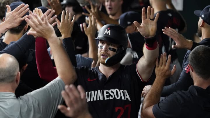 Aug 16, 2024; Arlington, Texas, USA; Minnesota Twins catcher Ryan Jeffers (27) is greeted in the dugout after scoring on a three-run home run by first baseman Carlos Santana (30) during the fifth inning against the Texas Rangers at Globe Life Field.