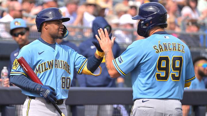 Feb 23, 2026; Peoria, Arizona, USA;  Milwaukee Brewers catcher Gary S‡nchez (99) is greeted by Milwaukee Brewers shortstop Eddys Leonard (80) after scoring on a triple by shortstop Jett Williams (76) in the first inning against the San Diego Padres at Peoria Sports Complex. Mandatory Credit: Jayne Kamin-Oncea-Imagn Images