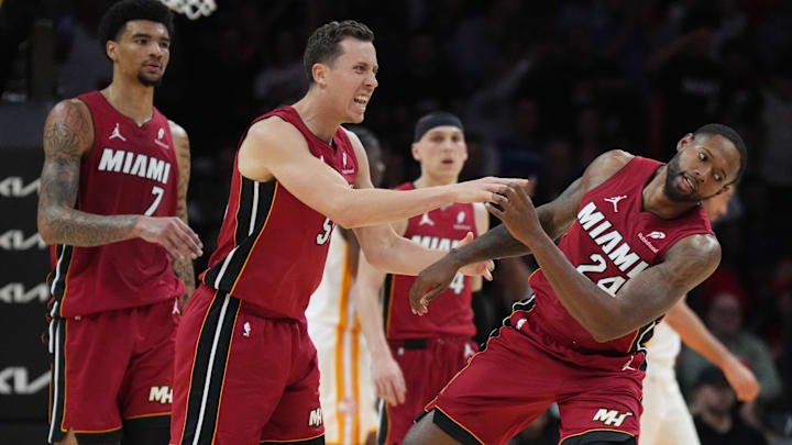 Feb 26, 2025; Miami, Florida, USA;  Miami Heat forward Duncan Robinson (55) playfully pushes forward Haywood Highsmith (24) following his assist on a three-point shot by Robinson that forced a timeout by the Atlanta Hawks in the second half at Kaseya Center. Mandatory Credit: Jim Rassol-Imagn Images