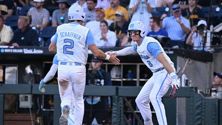 Jun 14, 2026; Omaha, NE, USA;  North Carolina Tar Heels shortstop Jake Schaffner (2) and center fielder Owen Hull (8) celebrate scoring against the West Virginia Mountaineers during the seventh inning at Charles Schwab Field. Mandatory Credit: Steven Branscombe-Imagn Images