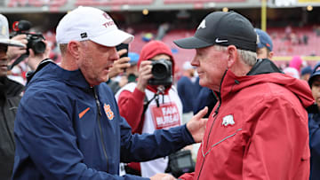 Oct 25, 2025; Fayetteville, Arkansas, USA; Auburn Tigers head coach Hugh Freeze shakes hands with Arkansas Razorbacks interim head coach Bobby Petrino after the game at Donald W. Reynolds Razorback Stadium. Auburn won 33-24. Mandatory Credit: Nelson Chenault-Imagn Images