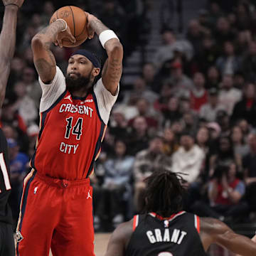 Feb 10, 2024; Portland, Oregon, USA; New Orleans Pelicans small forward Brandon Ingram (14) shoots the ball over Portland Trail Blazers center Ibou Badji (41) and guard Ashton Hagans (19) during the first half at Moda Center.