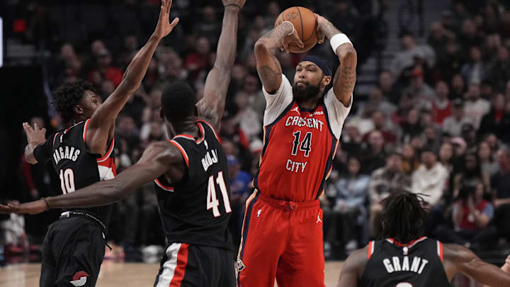 Feb 10, 2024; Portland, Oregon, USA; New Orleans Pelicans small forward Brandon Ingram (14) shoots the ball over Portland Trail Blazers center Ibou Badji (41) and guard Ashton Hagans (19) during the first half at Moda Center.