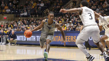 Mar 8, 2025; Morgantown, West Virginia, USA; West Virginia Mountaineers guard Javon Small (7) drives down the lane against UCF Knights guard Darius Johnson (3) during the first half at WVU Coliseum. Mandatory Credit: Ben Queen-Imagn Images