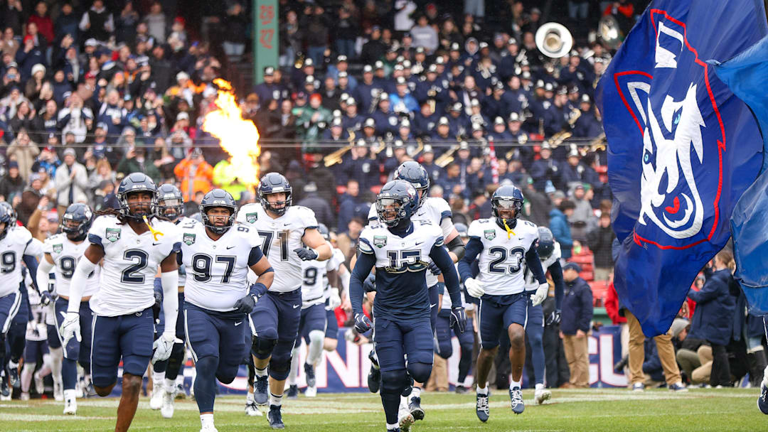 UConn's Rante Jones, left, and Tui Faumuina-Brown lead the team out of the tunnel during the third annual Wasabi Fenway Bowl against North Carolina at Fenway Park on Saturday, Dec. 28, 2024.