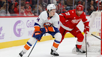 Nov 20, 2025; Detroit, Michigan, USA;  New York Islanders center Calum Ritchie (64) skates with the puck defended by Detroit Red Wings left wing J.T. Compher (37) in the first period at Little Caesars Arena. Mandatory Credit: Rick Osentoski-Imagn Images