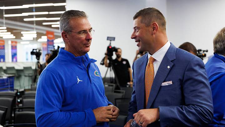 Dec 1, 2025; Gainesville, FL, USA; Florida Gators former head coach Urban Meyer and Florida Gators head coach Jon Sumrall talk after the press conference at the Heavener Football Training Center at the University of Florida. Mandatory Credit: Matt Pendleton-Imagn Images