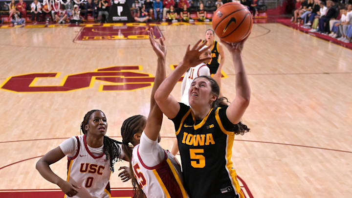 Jan 29, 2026; Los Angeles, California, USA; Iowa Hawkeyes guard Ava Heiden (5) is defended by USC Trojans forward Vivian Iwuchukwu (0) and guard Kara Dunn (25) as she drives for a basket in the second half at Galen Center. Mandatory Credit: Jayne Kamin-Oncea-Imagn Images