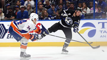 Mar 29, 2025; Tampa, Florida, USA;Tampa Bay Lightning center Jake Guentzel (59) passed the puck as New York Islanders defenseman Adam Boqvist (34) defends during the second period at Amalie Arena. Mandatory Credit: Kim Klement Neitzel-Imagn Images