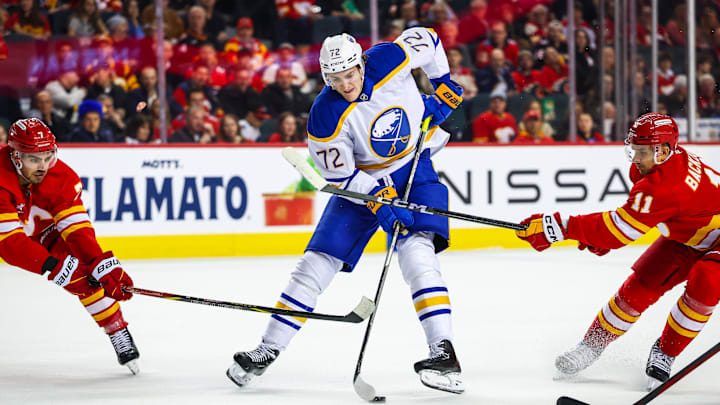 Jan 23, 2025; Calgary, Alberta, CAN; Buffalo Sabres center Tage Thompson (72) controls the puck against Calgary Flames center Mikael Backlund (11) and defenseman Kevin Bahl (7) during the first period at Scotiabank Saddledome. Mandatory Credit: Sergei Belski-Imagn Images