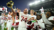 Nov 2, 2024; East Lansing, Michigan, USA;  Indiana Hoosiers offensive lineman Bray Lynch (74) holds up The Old Brass Spittoon after beating Michigan State at Spartan Stadium.