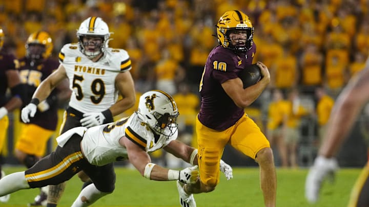 August 31, 2024; Tempe, Ariz.; USA; ASU quarterback Sam Leavitt (10) sprints downfield breaking a tackle from Wyoming linebacker Connor Shay (33) during a game at Sun Devil Stadium.