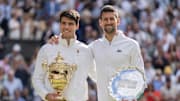 Carlos Alcaraz of Spain and Novak Djokovic of Serbia pose with their trophies at 2024 Wimbledon.