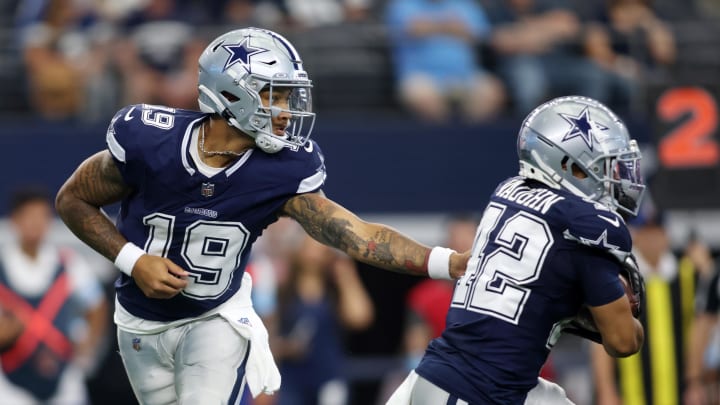 Dallas Cowboys quarterback Trey Lance (19) hands the ball off to running back Deuce Vaughn (42) 