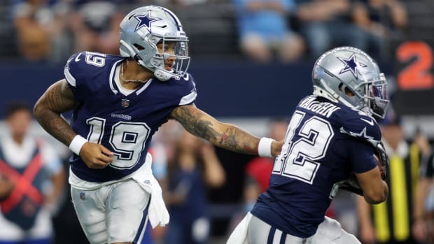 Dallas Cowboys quarterback Trey Lance (19) hands the ball off to running back Deuce Vaughn (42)