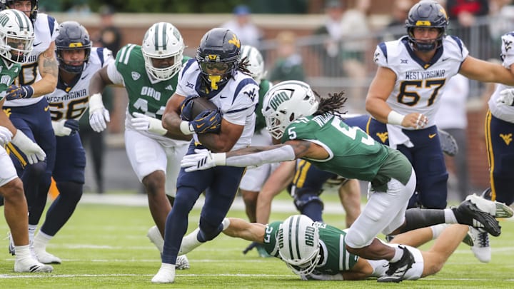Sep 6, 2025; Athens, Ohio, USA; West Virginia Mountaineers running back Jahiem White (1) runs the ball and is tackled by Ohio Bobcats safety Adonis Williams Jr. (5) during the first quarter at Peden Stadium. Mandatory Credit: Ben Queen-Imagn Images