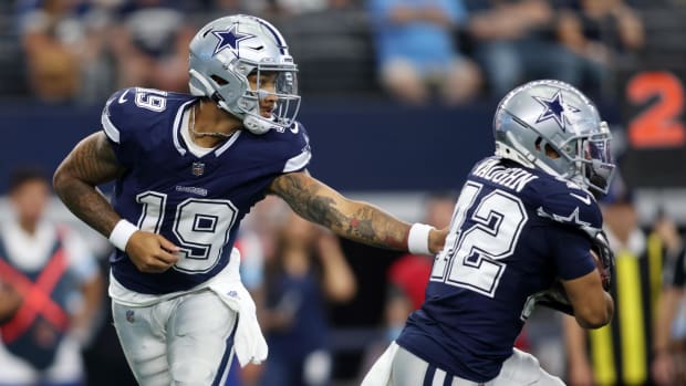  Dallas Cowboys quarterback Trey Lance (19) hands the ball off to running back Deuce Vaughn (42) 