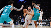 Oct 28, 2025; Miami, Florida, USA; Miami Heat guard Jaime Jaquez Jr. (11) drives to the basket against Charlotte Hornets forward Miles Bridges (0) and guard Lamelo Ball (1) during the third quarter at Kaseya Center. Mandatory Credit: Sam Navarro-Imagn Images