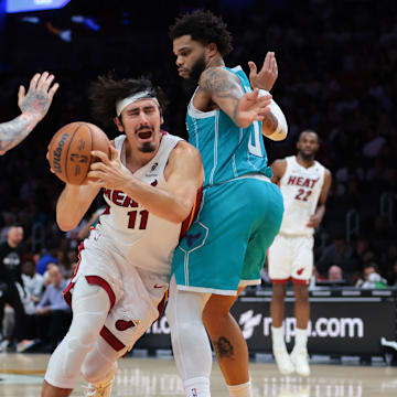 Oct 28, 2025; Miami, Florida, USA; Miami Heat guard Jaime Jaquez Jr. (11) drives to the basket against Charlotte Hornets forward Miles Bridges (0) and guard Lamelo Ball (1) during the third quarter at Kaseya Center. Mandatory Credit: Sam Navarro-Imagn Images