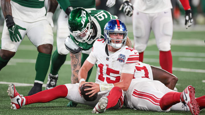 Aug 24, 2024; East Rutherford, New Jersey, USA; New York Giants quarterback Tommy DeVito (15) reacts after being sacked during the second half by New York Jets defensive end Braiden McGregor (91) at MetLife Stadium.  