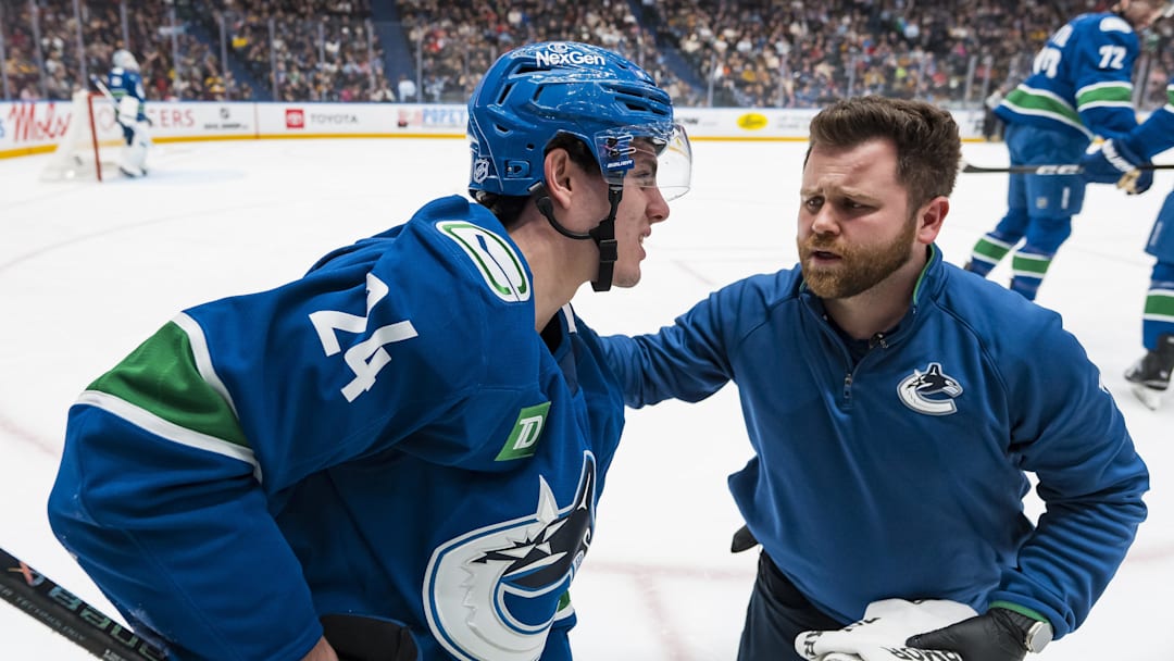 Jan 25, 2026; Vancouver, British Columbia, CAN; A member of the Vancouver Canucks training staff tends to injured defenseman Zeev Buium (24) against the Pittsburgh Penguins in the first period at Rogers Arena. Mandatory Credit: Bob Frid-Imagn Images