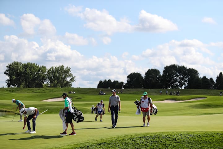 Michael Thompson walks to the 18th green while Richy Werensky and Charl Schwartzel look on in the final round of the 3M Ope