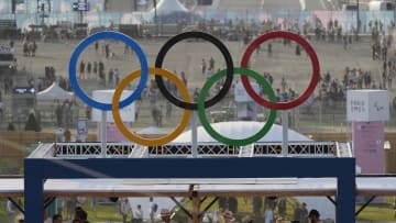 Jul 30, 2024; Paris, France; Fans watch from the top of the arena under a set of Olympic rings in a beach volleyball preliminary match during the Paris 2024 Olympic Summer Games at Eiffel Tower Stadium. Mandatory Credit: Katie Goodale-USA TODAY Sports