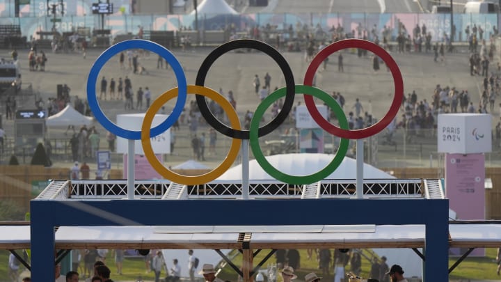 Jul 30, 2024; Paris, France; Fans watch from the top of the arena under a set of Olympic rings in a beach volleyball preliminary match during the Paris 2024 Olympic Summer Games at Eiffel Tower Stadium. Mandatory Credit: Katie Goodale-USA TODAY Sports