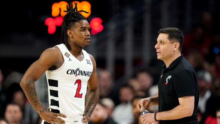 Cincinnati Bearcats head coach Wes Miller, right, talks with Cincinnati Bearcats guard Jizzle James (2) in the first half of a college basketball game against the Bradley Braves during a second-round game of the National Invitation Tournament,, Saturday, March 23, 2024, at Fifth Third Arena in Cincinnati.
