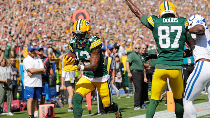 Green Bay Packers wide receiver Dontayvion Wicks (13) scores a touchdown against the Colts, thanks in part to a block by Romeo Doubs.