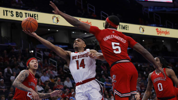 Mar 12, 2024; Washington, D.C., USA; North Carolina State Wolfpack guard Casey Morsell (14) shoots the ball as Louisville Cardinals forward Brandon Huntley-Hatfield (5) defends in the second half at Capital One Arena. Mandatory Credit: Geoff Burke-USA TODAY Sports