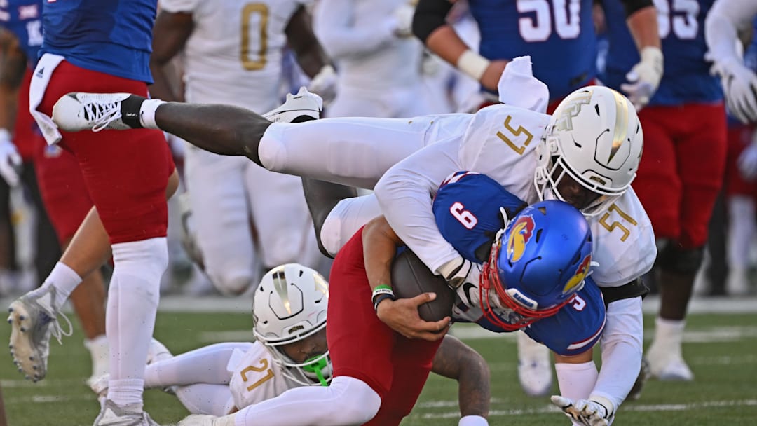 Oct 7, 2023; Lawrence, Kansas, USA;  UCF Knights defensive end Malachi Lawrence (51) tackles Kansas Jayhawks quarterback Jason Bean (9) during the second half at David Booth Kansas Memorial Stadium. Mandatory Credit: Peter Aiken-Imagn Images