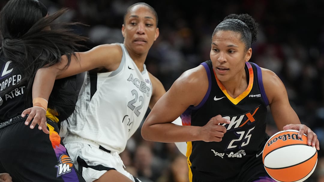 Aug 15, 2025; Phoenix, Arizona; Phoenix Mercury forward Alyssa Thomas (25) drives around Las Vegas Aces center A'ja Wilson (22) in the second half at Footprint Center. 