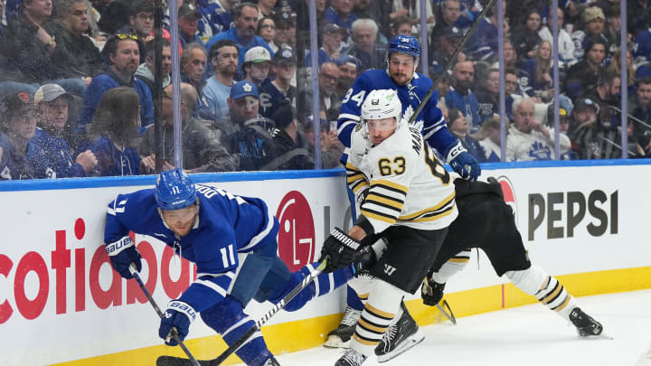 Apr 27, 2024; Toronto, Ontario, CAN; Boston Bruins left wing Brad Marchand (63) battles for the puck with Toronto Maple Leafs center Max Domi (11) during the first period in game four of the first round of the 2024 Stanley Cup Playoffs at Scotiabank Arena. Mandatory Credit: Nick Turchiaro-USA TODAY Sports