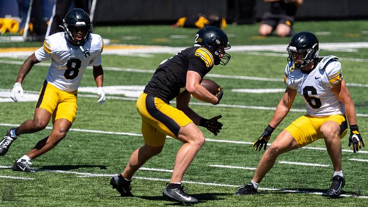 Iowa defensive backs Deshaun Lee (8) and Zach Lutmer (6) defend wide receiver Reece Vander Zee (2) as he runs for extra yards after a catch April 25, 2026 during the team’s spring practice at Kinnick Stadium in Iowa City, Iowa.