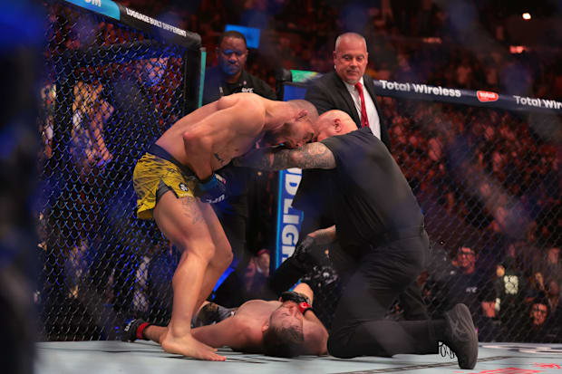 Jean Silva (blue gloves) reacts during his fight against Bryce Mitchell (red gloves) during UFC 314 at Kaseya Center. 