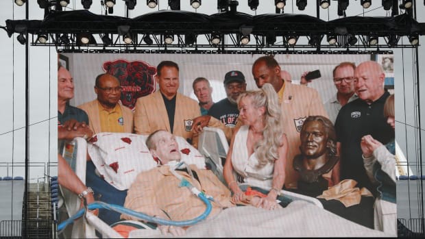 Steve McMichael is presented his bust at home with former teammates in the view they saw on a big board at Canton.